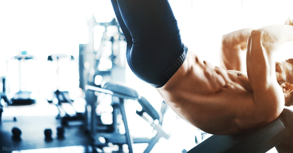 A man (model) in the gym working out his developed core muscles