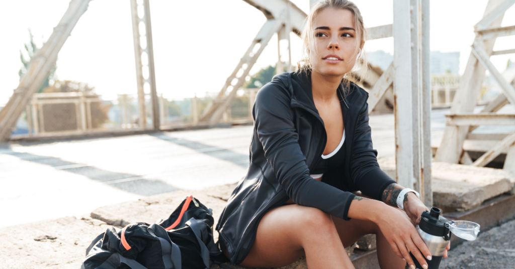 woman sitting with water bottle after a workout